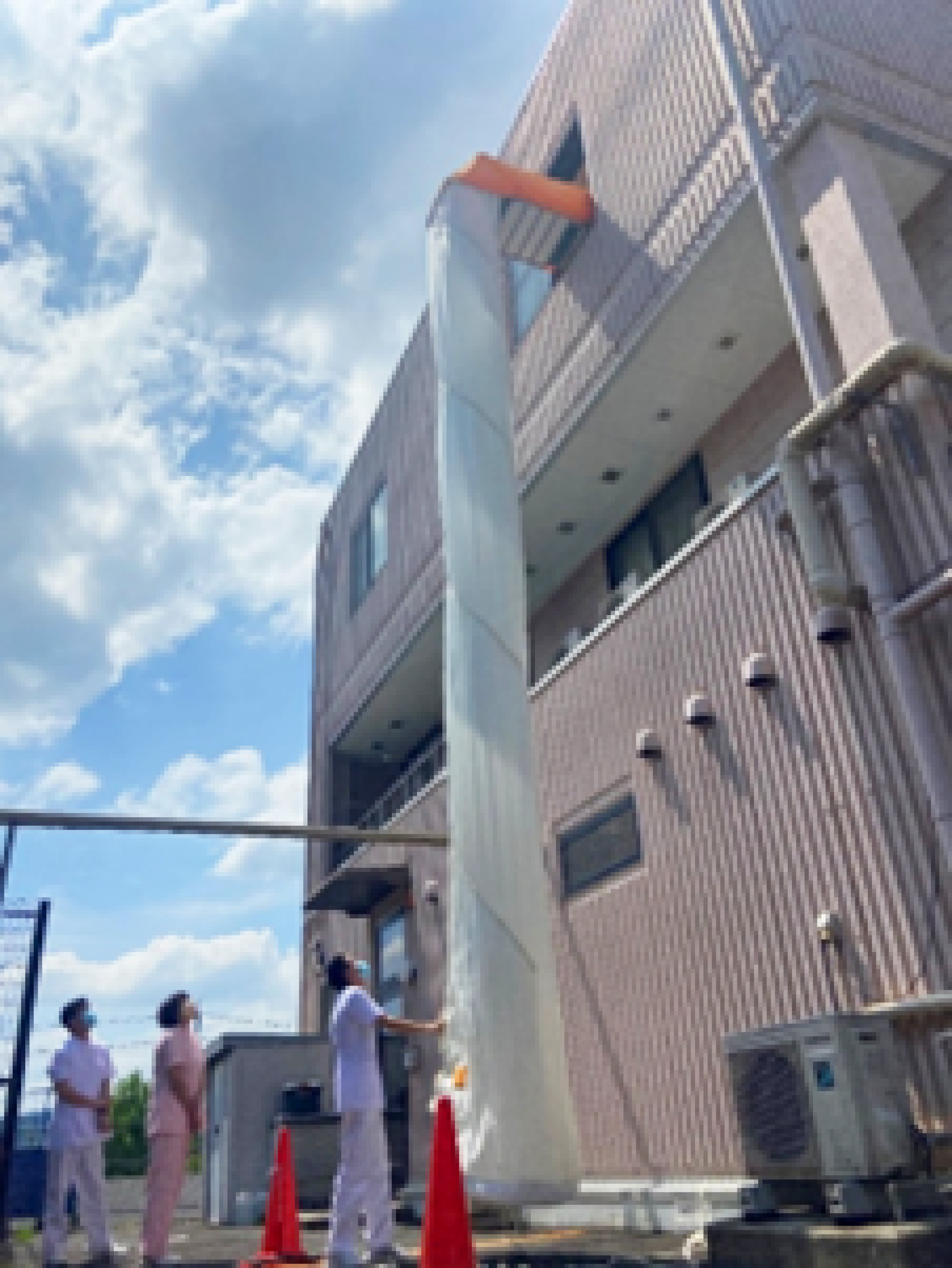 垂直降下型救助袋の使用方法の確認。スタッフが実際に体験し、安全に使用できることを確認しました。